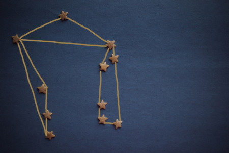 The zodiacal constellation of Libra is schematically laid out by small stars. Dark gray background, vignetting. The picture is made by the author.の写真素材