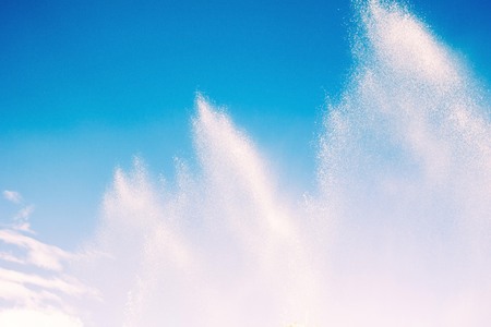 White splashes on a blue background. Humidification of the air, freshness, coolness. Fountain of...