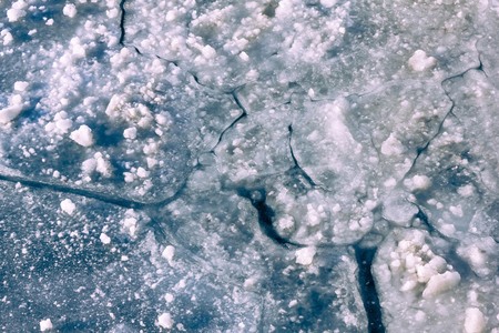 Blue ice, large cracks, rough texture. Frosts, cold snap, winter weather. Daytime side lighting, top...