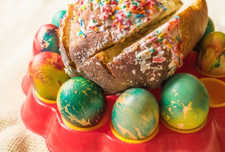 On the table are colored eggs and Easter cake. Preparation for Easter, a symbol of a religious...