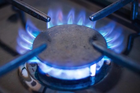 Gas stove, blue fire. The use of natural gas for domestic purposes. The front edge is blurred.