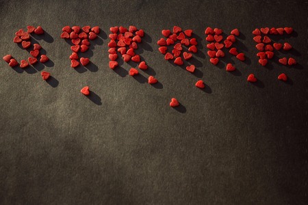 Red inscription on a black background. The letters are scattered into small pieces. Copy space, side...