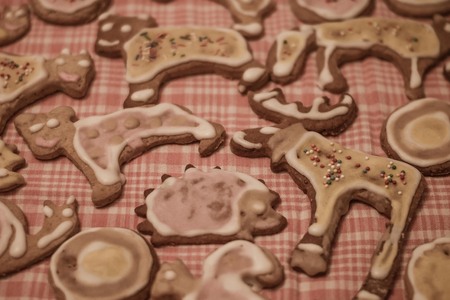 Christmas cookies, funny animal figures. Pink checkered tablecloth, cozy home decor. Vintage toning,...