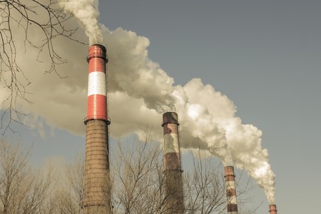 Pipes smoke in the sky, pollution of the atmosphere. Poor environmental conditions. Muffled tones, copy space.の写真素材