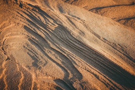 Desert, sand dune, layered structure. Evening sunlight, toning, vignetting.