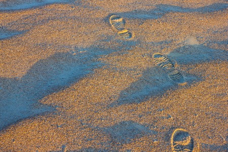 Traces of rough shoes go away. Wanderings, love to travel. Sandy surface, natural landscape. Lateral...