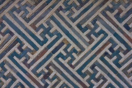 Concrete wall with a fancy ornament, decor element. Blue lines, swastika symbol. Skillful work.の写真素材