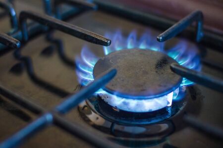 A ring on the gas stove. Use of domestic gas, cooking. The edges are blurred, dark background.の写真素材