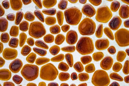 Wall, detail of the interior. Light surface with yellow, brown pebbles, mosaic, abstraction. Old...