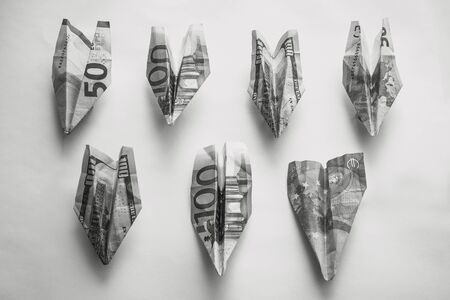 Banknotes are folded in the form of airplanes. Losses, financial problems, lack of funds. In black and white. View from above.の写真素材
