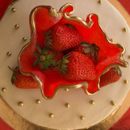 Beautiful, delicious cake with strawberries. Summer, festive mood. Red, white and gold color, decoration. View from above.の写真素材