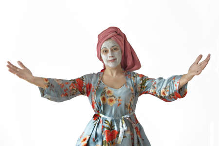 Woman in pajamas, face cream. Hands spread apart, a welcoming gesture. Joyful wife.の写真素材