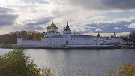 Travel along the Golden Ring of Russia, pilgrimage tourism. Traditional Russian monastery in Kostroma. White walls, golden domes. View from the water.の写真素材