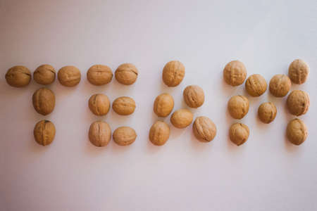The inscription team is made of large nuts. Strong, close-knit team. Light background, vignetting.の写真素材