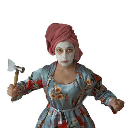 Tense woman with a kitchen ax. Domestic violence, aggression, clarification of relationships, protection of one's rights.の写真素材
