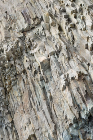 Gray, cold texture, natural stone. Layered rock with cracks and chips. Bottom view.の写真素材