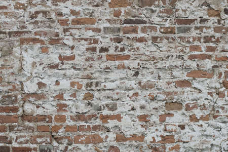 Old house, dirty orange bricks. Remains of plaster and cement on the wall. Daylighting.の写真素材