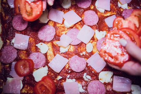 tomato paste on uncooked pizza Mozzarella cheese salamiの写真素材