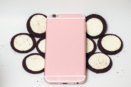 Modern mobile smartphone chocolate cookies stacked served milk the concept of a modern mobile...