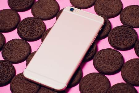 Modern mobile smartphone chocolate cookies stacked served milk the concept of a modern mobile operating systemの写真素材