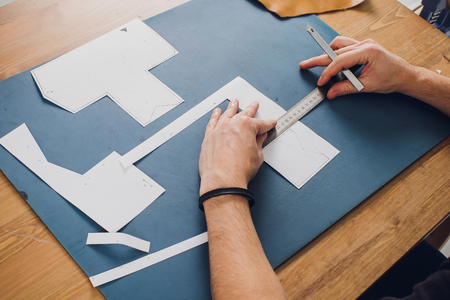 leather craftsman working making products at table in workshop studioの写真素材