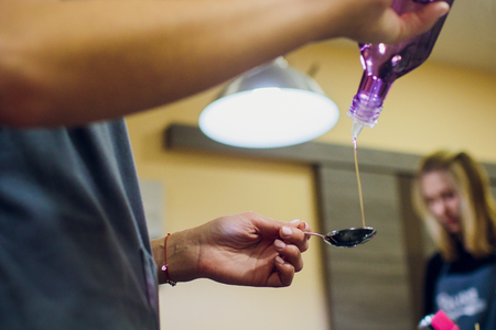 Pouring olive oil in the salad over a spoonの写真素材