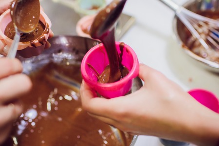 Woman preparing dough for chocolate pie on table close up