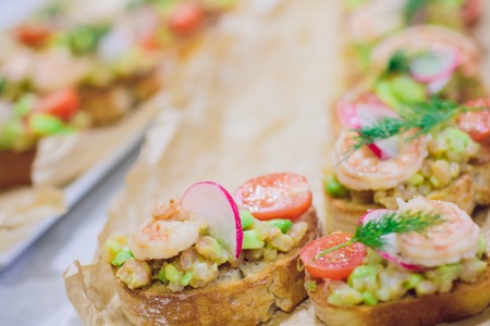 Bruschetta italian snack sandwiches with avocado cream and prawns decorated by parsley and chilli peppersの写真素材