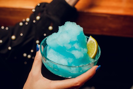 glass of blue cocktail with lemon slice drinkの写真素材