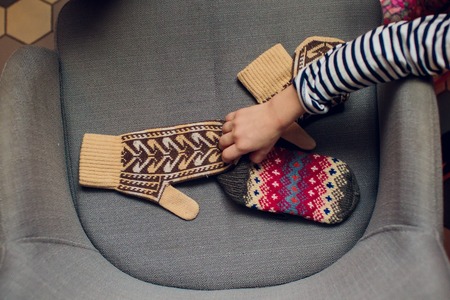 Children's handles in mittens color armchair winterの写真素材