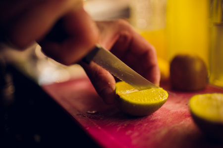 lemon lime slices with mint leaves and knife on stone boardの写真素材