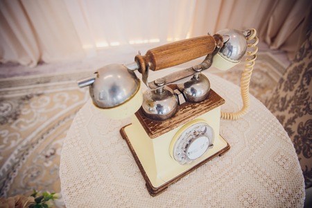 Retro rotary telephone on wood table yellowの写真素材