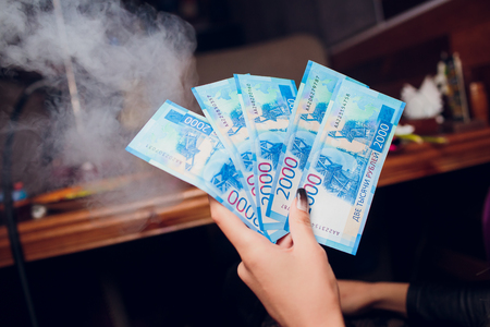 new Russian banknotes denominated in 2000 rubles in female hands close-up on a club background girl holds 5 billsの写真素材