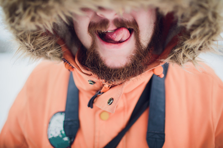 bearded man in winter hat smiling portrait extreme tongueの写真素材