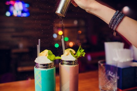 Evening at the bar. The barman pours alcohol into a glass. Club handの写真素材