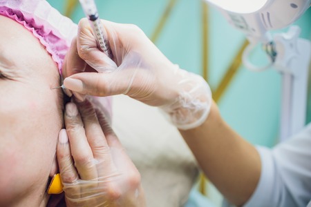 Professional holding the needle cannula on hand. Closeup. Female
