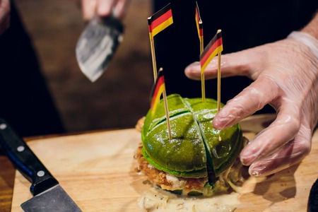 Chief cook preparing fresh burger in the kitchen.Burger restaurant menu cooking process.