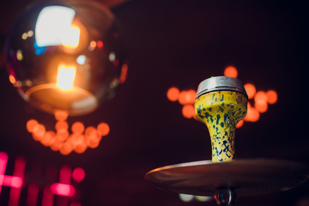 Preparing the shisha, aka nargile or hookah at a restaurant by placing the charcoals on top.