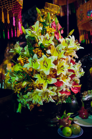 Altar at the feet of a standing Buddha in a Buddhist templeの写真素材