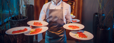 the waiter has a lot of hands, a lot of plates with food, the concept of a restaurant, Ganeshの写真素材