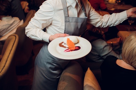 Waiters carrying plates with meat dish at a wedding foodの写真素材