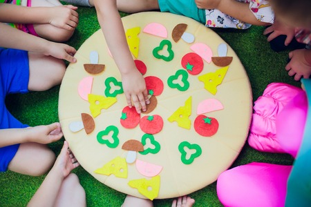kids are playing. pillow pizza. The hands are fastening with Velcro ingredients for pizzaの写真素材