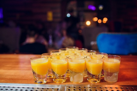 Shots on a bar counter top yellow color of the drink laid out with a billiard pyramid