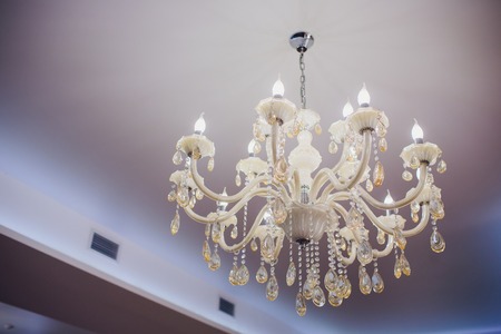 Close-up of a beautiful crystal chandelier under ceilingの写真素材