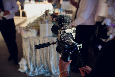 Filmmaking. Men with High Definition Modern Video Camera Shooting Some Video.Photographer in park. Models are working.の写真素材