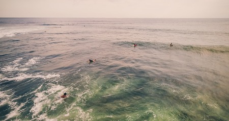 Aerial view of surfers and wave in tropical ocean. Top viewの写真素材