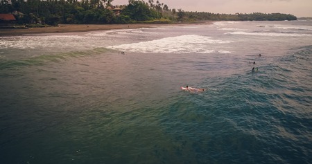 Aerial view of surfers and wave in tropical ocean. Top viewの写真素材