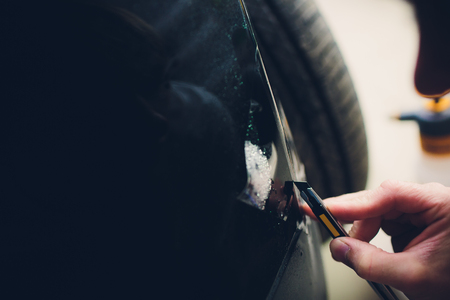 Worker hands installs car paint protection film.の写真素材