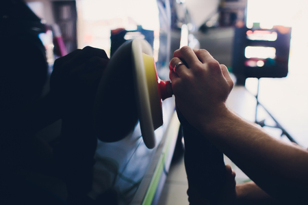 Car detailing - Hands with orbital polisher in auto repair shop.の写真素材