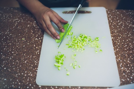 woman hands cutting vegetables on kitchen blackboard. Healthy food. Woman preparing vegetables, cooking healthy meal in the kitchen. Preparing dishesの写真素材